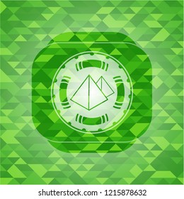 pyramids icon inside green emblem. Mosaic background