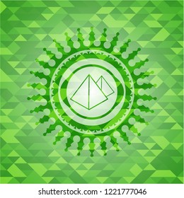 pyramids icon inside green emblem with mosaic ecological style background