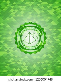 pyramids icon inside green emblem with mosaic background
