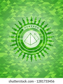 pyramids icon inside green emblem with mosaic ecological style background