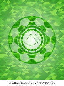 pyramids icon inside green emblem with mosaic ecological style background