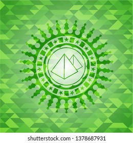 pyramids icon inside green emblem. Mosaic background