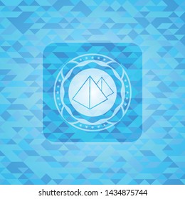 pyramids icon inside light blue emblem with mosaic background