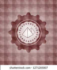 pyramids icon inside red seamless badge with geometric pattern background.
