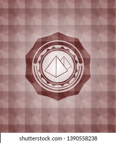 pyramids icon inside red seamless badge with geometric pattern background.
