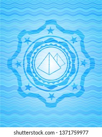 pyramids icon inside water wave representation badge.