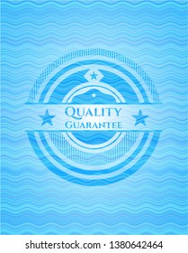 Quality Guarantee light blue water emblem.