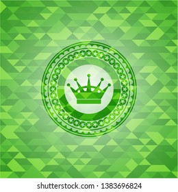 queen crown icon inside green emblem. Mosaic background