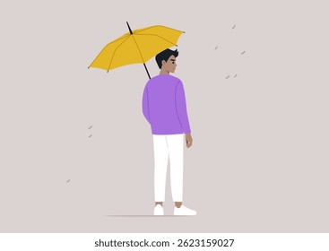 In a quiet urban environment, a person standing under a vibrant yellow umbrella as droplets of rain fall around them, fostering a sense of safety amidst the wet weather