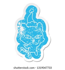 quirky cartoon distressed sticker of a cat wearing santa hat