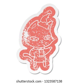 quirky cartoon distressed sticker of a cat staring wearing santa hat