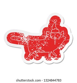 quirky cartoon distressed sticker of a cat wearing santa hat