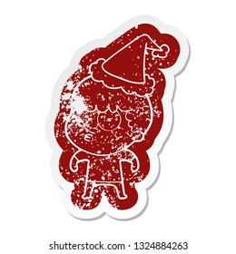 quirky cartoon distressed sticker of a curious boy wearing santa hat