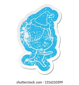 quirky cartoon distressed sticker of a girl in onesie wearing santa hat