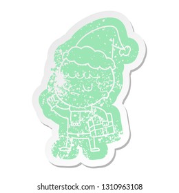 quirky cartoon distressed sticker of a grumpy boy wearing santa hat