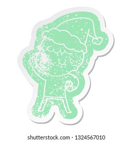 quirky cartoon distressed sticker of a grumpy boy wearing santa hat