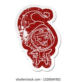 quirky cartoon distressed sticker of a laughing astronaut wearing santa hat