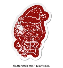 quirky cartoon distressed sticker of a lion with christmas present wearing santa hat