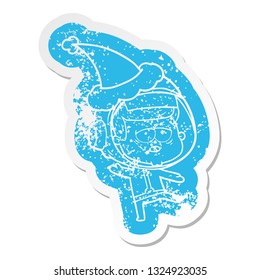 quirky cartoon distressed sticker of a tired astronaut wearing santa hat