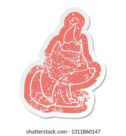 quirky cartoon distressed sticker of a wolf whistling wearing santa hat