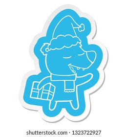 quirky cartoon  sticker of a bear with present wearing santa hat