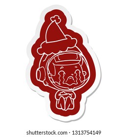 quirky cartoon  sticker of a crying astronaut wearing santa hat
