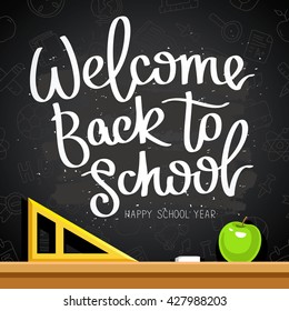 Quote "Welcome back to school. Happy school year." The trend calligraphy. Vector illustration on a black chalkboard with the school contour icons, apple, chalk and a triangle. 