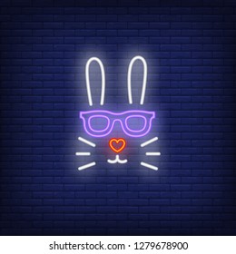 Rabbit neon sign. Easter bunny face in sunglasses with heart shaped nose on brick wall background. Vector illustration in neon style for topics like spring, Easter, celebration