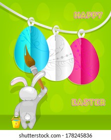 Rabbit paints Easter eggs. Easter card