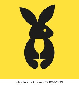 Plantilla de vectores de concepto de espacio negativo con logotipo de vidrio de conejo. Símbolo de vidrio de vino de contención de conejo