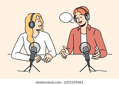 Radio show hosts sit around table with microphones discussing latest news preparing online podcast. Man and woman work as radio announcers and create audio broadcast in sound recording studio.