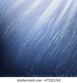 rain in rays of light on a dark background