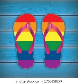 Rainbow colored flip-flops on the blue wooden background.  Eps 10 vector file.