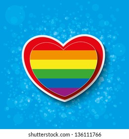 Rainbow paper heart with bubbles on the blue background.