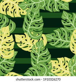 Random abstract tropical seamless pattern with green and yellow colored monstera elements. Striped background. Graphic design for wrapping paper and fabric textures. Vector Illustration.