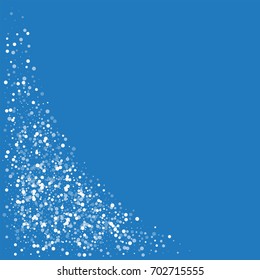 Random falling white dots. Bottom left corner on blue background. Vector illustration.