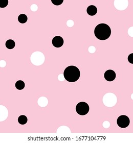 Random playful pattern of white and black polka dots on pink background.