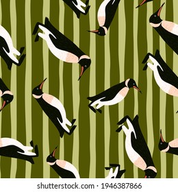 Random seamless pattern with hand drawn penguins abstract ornament. Olive green striped background. Decorative print for fabric design, textile print, wrapping, cover. Vector illustration.