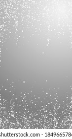 Random white dots Christmas background. Subtle flying snow flakes and stars on grey background. Alluring winter silver snowflake overlay template. Popular vertical illustration.