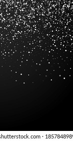Random white dots Christmas background. Subtle flying snow flakes and stars on black background. Appealing winter silver snowflake overlay template. Graceful vertical illustration.