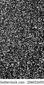 Random white dots Christmas background. Subtle flying snow flakes and stars on black background. Artistic winter silver snowflake overlay template. Appealing vertical illustration.
