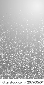 Random white dots Christmas background. Subtle flying snow flakes and stars on grey background. Amazing winter silver snowflake overlay template. Resplendent vertical illustration.