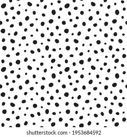 Randomly scattered black polka dots of various sizes and shapes on a white background. Seamless vector abstract pattern animal skin, stones, polka dots. Design for print on various surfaces.