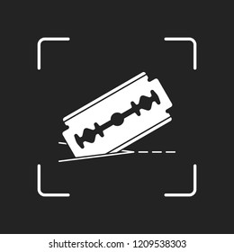 razor blade and cutting line. simple icon. White object in camera autofocus on dark background