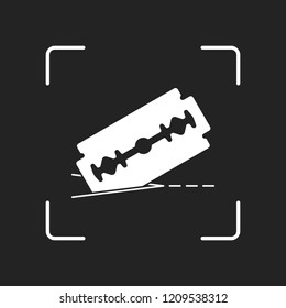 razor blade and cutting line. simple icon. White object in camera autofocus on dark background