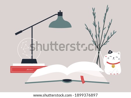 Reading a book at the desk, hobby and education, a desk decorated with a crystal globe, a lamp and a lucky cat figurine, cozy atmosphere