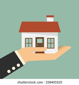 Real estate offer. Businessman holding a house