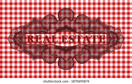 REAL ESTATE text inside Linear red checkered tablecloth realistic emblem. Restaurant classic background. Artistic illustration. 