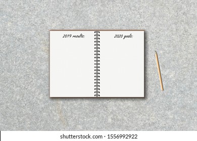 realistic 3d blank open ring spiral notebook with 2019 results, 2020 goals text lettering and wooden pencil on concrete texture background, top view flat lay, stock vector illustration clipart mockup