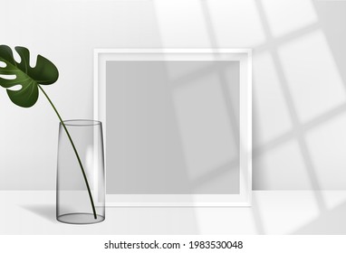 Realistic blank picture frame  hanging on a light wall from the Front with overlay shadows and tropical plants. Design Template for Mock Up.
